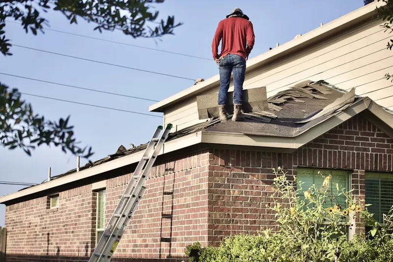 Professional roofer working on a residential roof in Quinton